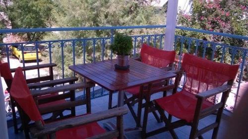 阿基奥斯基利考斯Smaragdi Studios and Rooms的阳台上的一张带椅子的木桌和盆栽植物