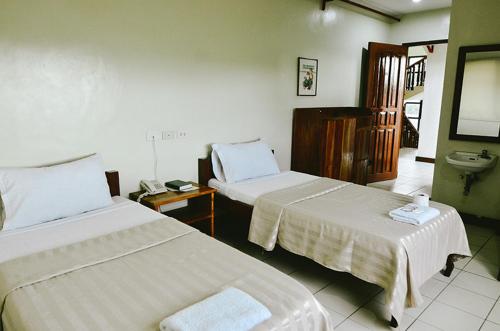 伊洛伊洛埃尔哈希恩德罗私人酒店的酒店客房设有两张床和盥洗盆