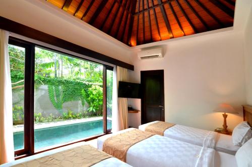 塞米亚克New Pondok Sara Villas - CHSE Certified的一间卧室设有两张床和大窗户