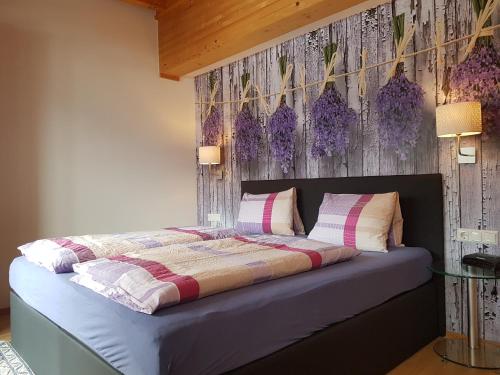 弗拉塔赫葛莱施穆尔酒店的卧室配有一张墙上紫色鲜花的床