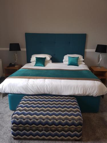 坎贝尔城Ardshiel Hotel的一间卧室配有一张大床和蓝色床头板