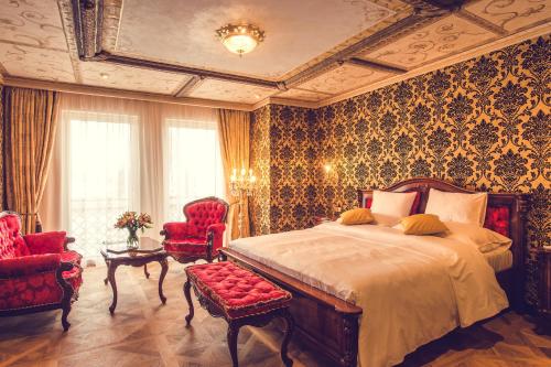 因德日赫城堡Hotel Florian Palace的一间卧室配有一张大床和两把椅子