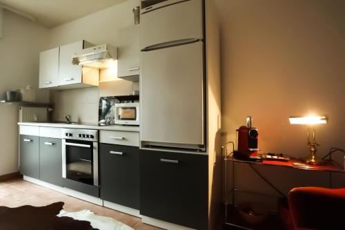 菲尔恩海姆Kant-Haus的厨房配有白色橱柜和大冰箱。