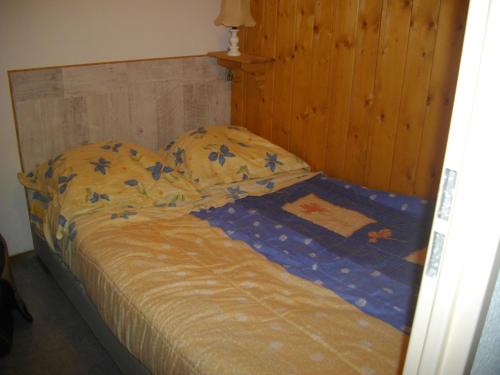 莱鲁斯Les Cretets的卧室内的一张床位,配有木制床头板