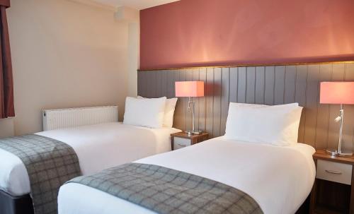 邓迪Fishermans Tavern的酒店客房设有两张床和两盏灯。