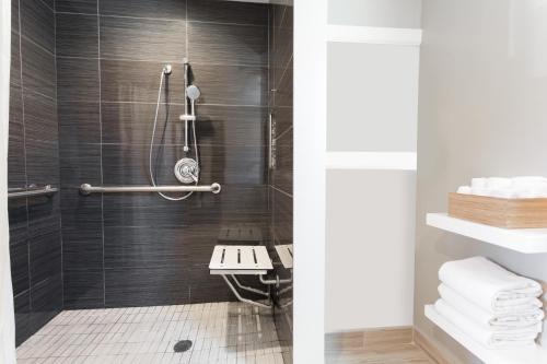 伯克利伯克利旅行者酒店的浴室设有黑色瓷砖淋浴。