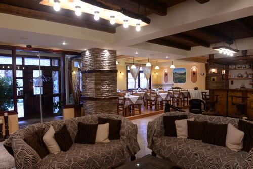 卡拉维塔阿尼西斯酒店的一间带两张沙发的客厅和一间用餐室