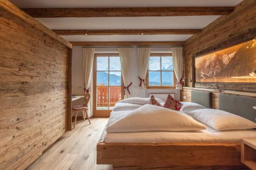 圣坎迪朵Egarterhof的一间卧室设有两张床和木墙