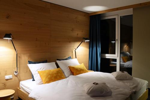 波鸿克劳狄斯酒店 的卧室配有一张白色大床和木墙