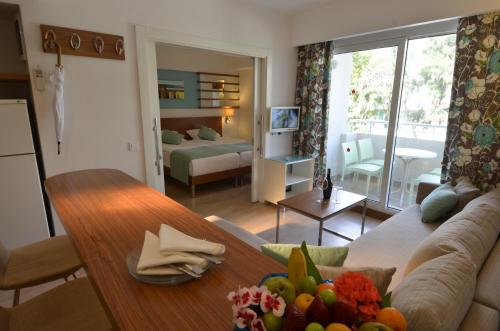 锡德Calimera Side Resort的客厅配有沙发和桌子