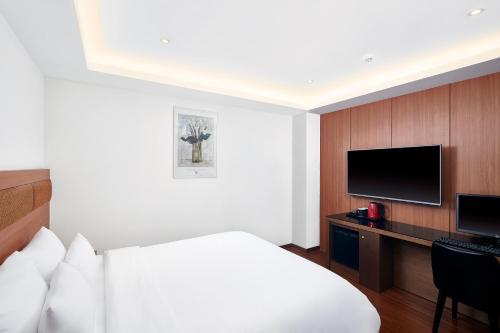 釜山雄狮酒店的酒店客房配有一张床和一张书桌及一台电视