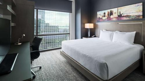 泽西市泽西塞缇凯悦大厦酒店的配有一张床、一张书桌和一扇窗户的酒店客房