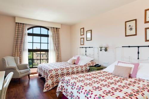 萨洛PortAventura Hotel Gold River - Includes PortAventura Park Tickets的一间卧室设有两张床和窗户。