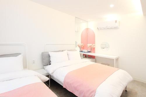 首尔Orbit - For foreigners only的一间卧室配有两张床和一张带镜子的书桌