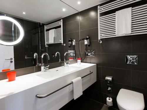 汉诺威汉诺威多梅洛酒店的浴室设有2个水槽和镜子