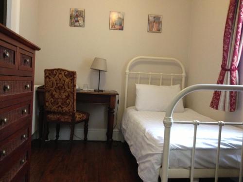 伦敦巴勒姆旅馆的一间卧室配有一张床、一张桌子和一把椅子