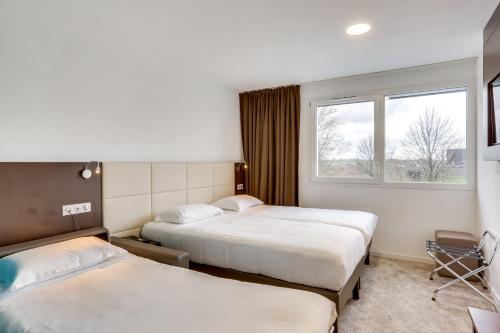 凯恩Inspiration by balladins Caen Mémorial的酒店客房设有两张床和窗户。