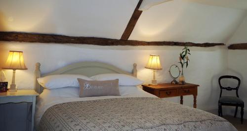 奇切斯特Nightingale Cottage Bed and Breakfast的一间卧室配有一张带两张桌子和两盏灯的床。
