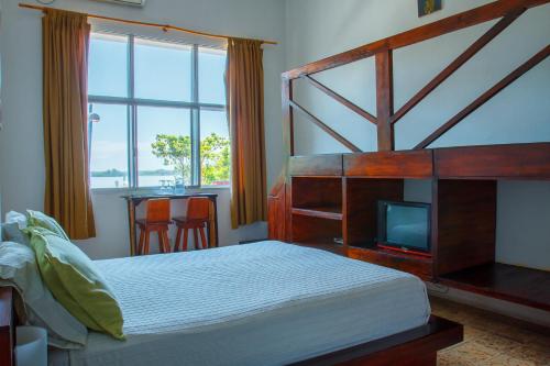 瓜亚基尔曼索精品宾馆的一间卧室设有一张床、一台电视和一个窗口。