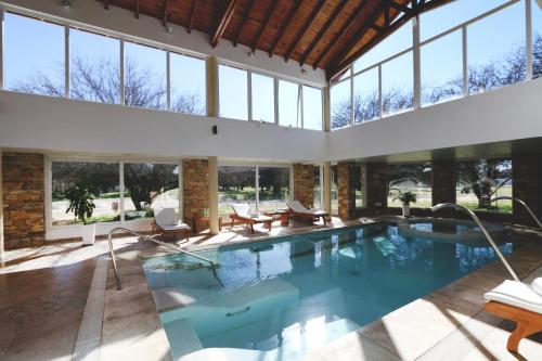 圣罗莎拉凯姆皮纳俱乐部酒店& Spa的室内游泳池,带窗户的大房间