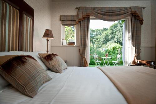 贝里圣埃德蒙兹拉文伍德豪尔酒店的一间卧室设有一张床和一个大窗户