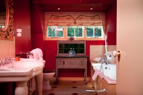 贝里圣埃德蒙兹拉文伍德豪尔酒店的一间带两个盥洗盆、浴缸和卫生间的浴室