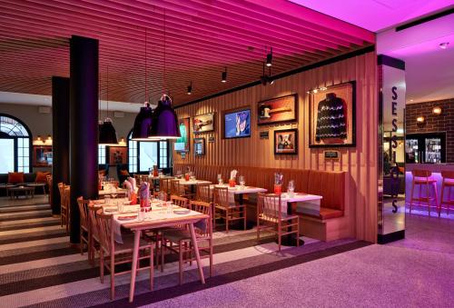 达沃斯达沃斯硬石酒店的餐厅配有桌椅和紫色照明
