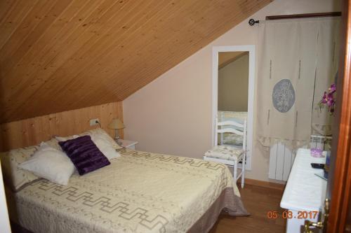 庞特维德拉Casa Rural Os Carballos的一间卧室设有一张床和木制天花板