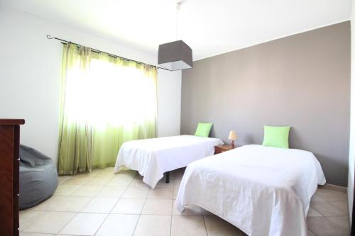 阿尔布费拉Dinita Apartamento nº4的客房设有两张床和窗户。