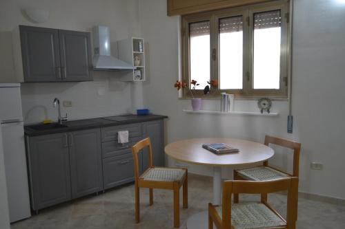 圣维托诺曼La Tana di Cruk的厨房配有桌子、两把椅子和水槽