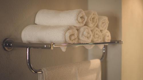 瓜达拉哈拉Hotel Belisario INN的浴室毛巾架上的一组毛巾