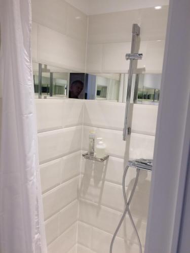 拉于尔普源头花园住宿加早餐旅馆的白色的浴室设有淋浴,镜子里的人可以淋浴
