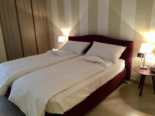 加尔多内-里维耶拉apartment Zagara - Gardone Riviera center的一间卧室配有一张带两个白色枕头的大床
