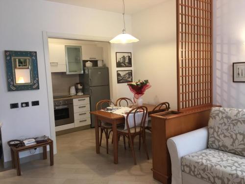 加尔多内-里维耶拉apartment Zagara - Gardone Riviera center的厨房以及带桌椅的起居室。