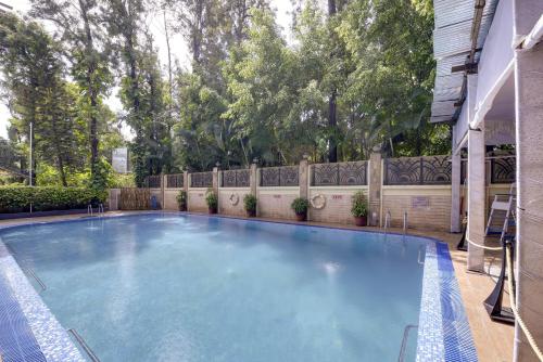 浦那Pride Hotel Pune的一个带围栏的院子内的一个大型游泳池