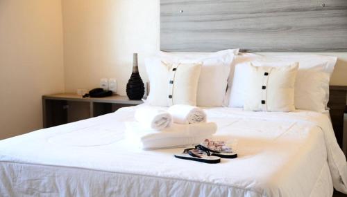 马卡帕多福酒店的一张带毛巾和拖鞋的白色床
