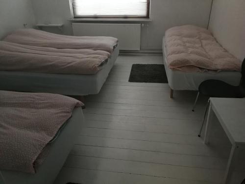 KolindPasescia Bed and Breakfast.的客房设有两张床、一张桌子和一个窗户。