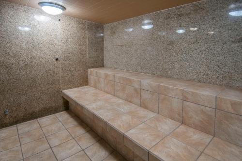 俄克拉何马城Governors Suites Hotel Oklahoma City Airport Area的浴室设有棕色瓷砖和淋浴。