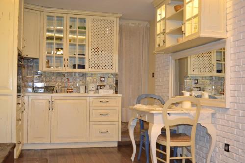 索非亚Vintage Lozenets Apartment的厨房配有白色橱柜和桌椅
