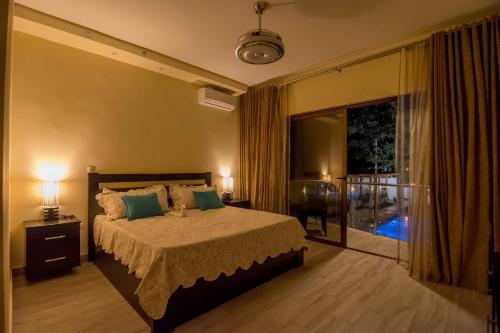 苏莎亚加勒比钻石精品酒店的一间卧室配有一张带两盏灯的床和一个阳台