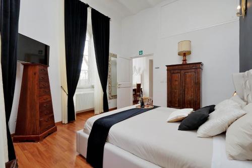 罗马斗兽场甜蜜公寓的卧室配有一张白色大床和电视。