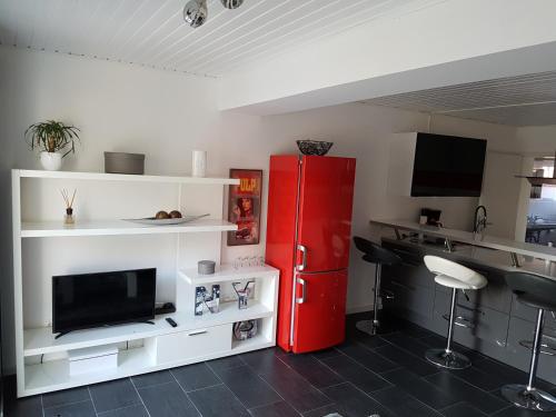 埃朗根Häuslinger Ferienwohnung的厨房配有红色冰箱和白色架子