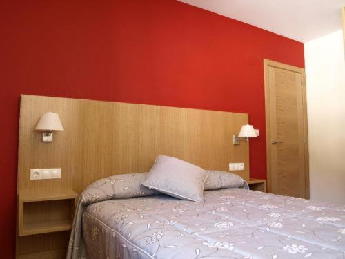 艾普约德加卡佩尼亚特雷拉度假公寓式酒店的一间卧室设有一张床和红色的墙壁