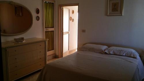 马蒂纳塔attico centro mattinata的一间卧室配有一张床、梳妆台和镜子