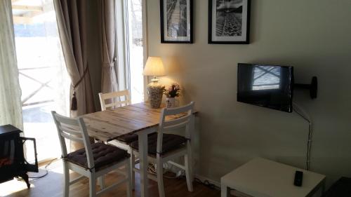 乌拉勒德Sjönära Ullared的餐桌、椅子和墙上的电视