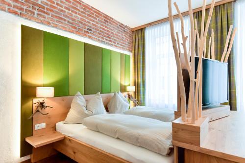 塔亚河畔魏德霍芬Konditorei Müssauer的一间卧室设有两张床和绿色的墙壁