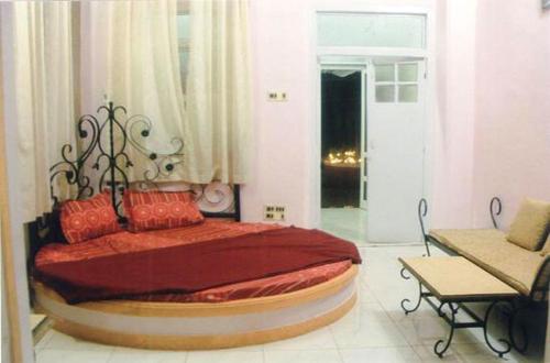马泰兰The Wayside Inn的一间卧室配有一张带红色枕头的大床