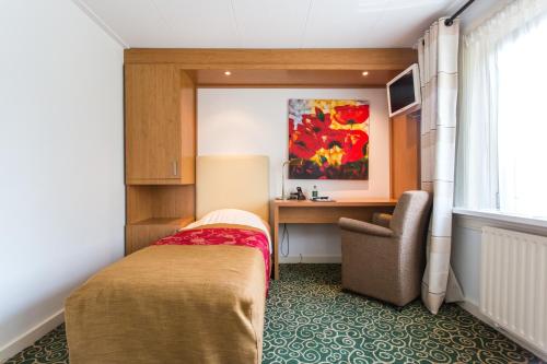 Hummelo戈登卡佩咖啡厅酒店的一间卧室配有一张床、一张桌子和一把椅子