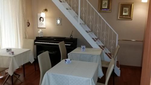 塔兰托soggiorni & pernottamenti TURNONE的一间带2张桌子和钢琴的用餐室