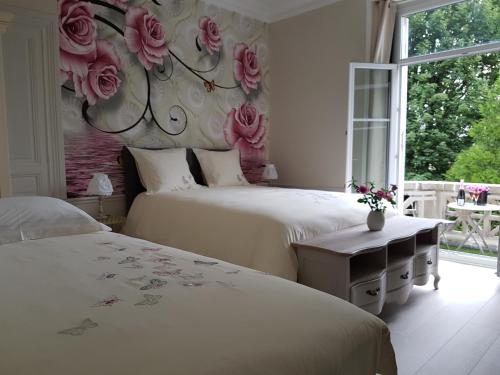 埃佩尔奈La Demeure d'Elodie的卧室设有两张床,墙上挂着玫瑰花